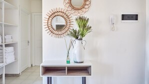 A hallway with a white console table, a mirror, and a vase with green plants. - Marinella in Golfo Aranci (Golfo Aranci)