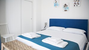 A hotel room with a bed, a chair, and artwork on the wall. - Spiaggia del Principe (Arzachena)