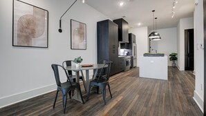 A modern kitchen with dark cabinetry, a central island, and pendant lighting.