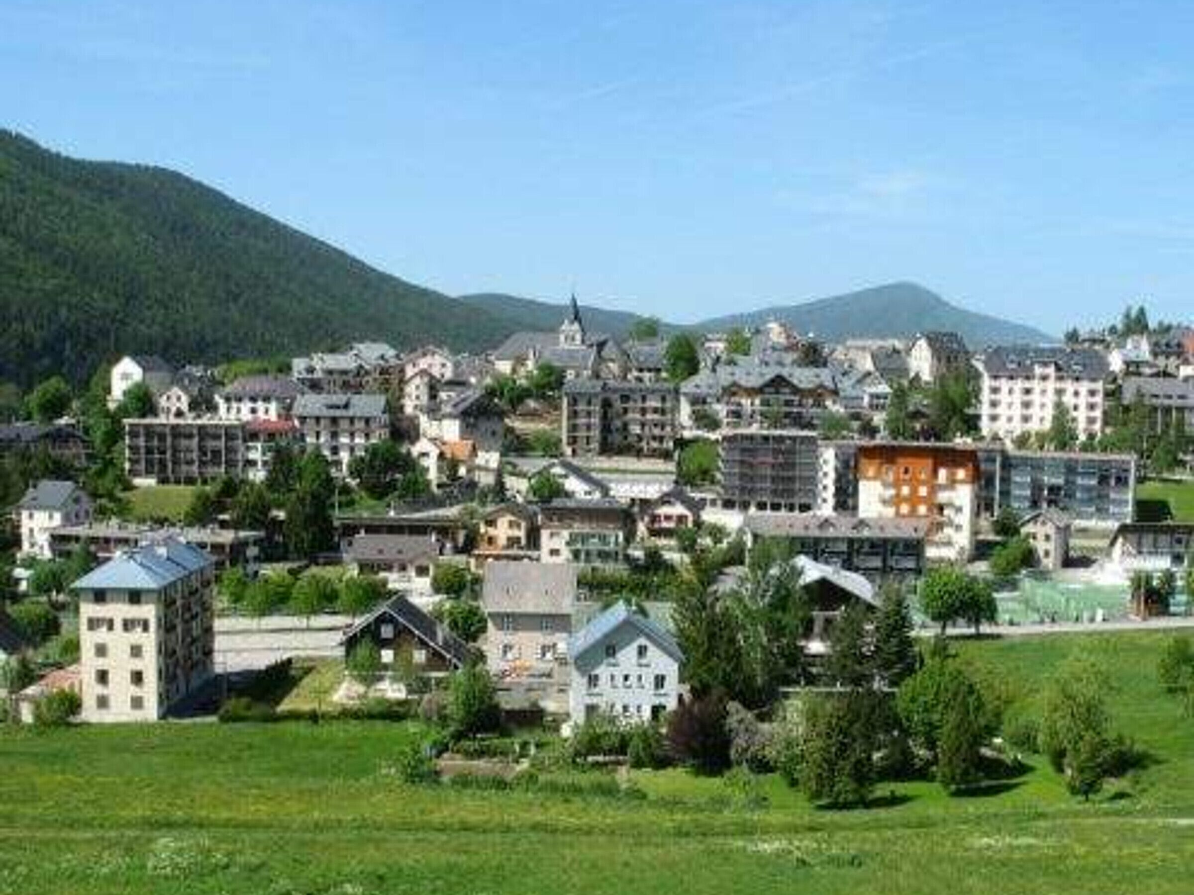 Una cittadina con un mix di edifici tradizionali e moderni, immersa nel verde delle colline.