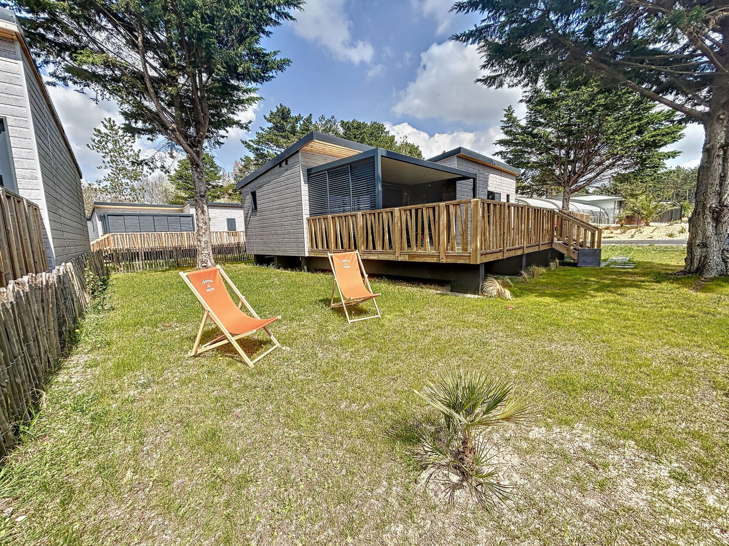 Ein moderner Wohnmobil mit einer Holterrasse und einer überdachten Veranda.
