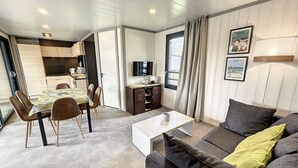 Ein modernes Wohnzimmer mit einer Couch, einem Couchtisch und einem Essbereich mit Stühlen und einem Tisch.