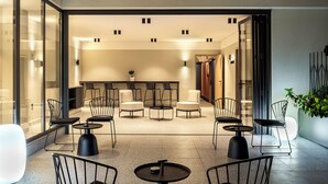 Eine moderne Lobby mit Sitzgelegenheit, Glaswänden und einer Pflanze.