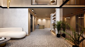 Ein modernes Interieur mit einer Rezeption, einem weißen Sofa und Zimmerpflanzen.