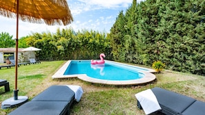 A swimming pool with lounge chairs and a flamingo float. - La Bastide des Joncquiers (L'Isle-sur-la-Sorgue)