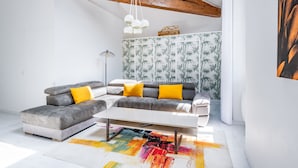 A modern living room with a sectional sofa, a white coffee table, and a colorful rug. - La Bastide des Joncquiers (L'Isle-sur-la-Sorgue)