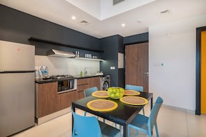 Una cocina moderna con una mesa de comedor, sillas y una cafetera.
