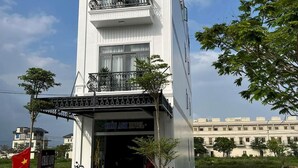 Un hotel con fachada blanca, balcones y un cartel que dice "CHAU ANH HOTEL".