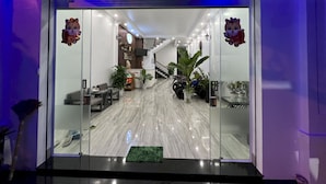 La entrada del Hotel Châu Anh, con mostrador de recepción, zona de estar y una escalera que lleva al piso superior.