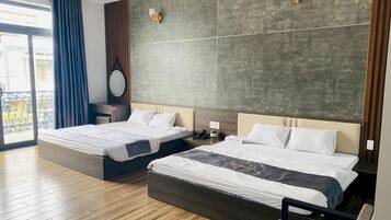 A hotel room with two beds, a large window, and a balcony.