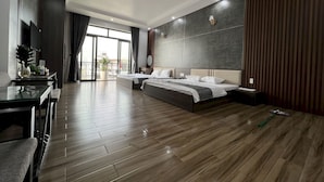 Una habitación de hotel moderna con una cama grande, un escritorio y un balcón con vistas.