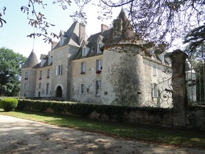 A large, historic stone building with multiple chimneys, arched windows, and a prominent turret. - Golf getaway and relaxation at Domaine de Bisseret (Lavault-Sainte-Anne)