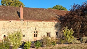 A rustic stone building with a sloped roof, a central door, and small windows. - Golf getaway and relaxation at Domaine de Bisseret (Lavault-Sainte-Anne)