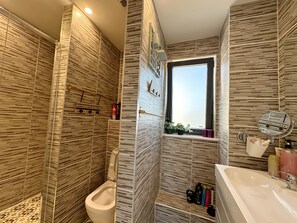 Une salle de bain moderne avec des toilettes, un lavabo et une fenêtre.