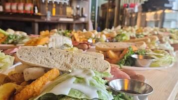 A buffet with various dishes, including sandwiches and salads, in a restaurant setting.