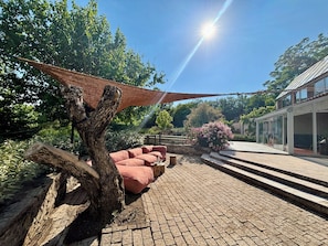 A paved outdoor area with a tree, a red bench, and a glass building. - Familly house in Sault 7 people : Le Pré de la Reyne. (Sault)