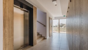 Un pasillo moderno con una pared de acento de madera, una escalera y vistas al exterior.