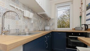 Una cocina moderna con salpicadero estampado, encimera de madera y electrodomésticos integrados.