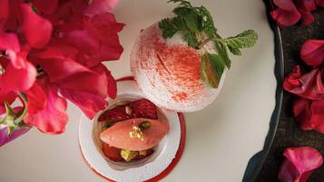 Dessert met aardbeien en muntblaadjes op een wit bord.