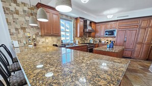 Cuina amb taulells de granat, armaris de fusta i una illa gran.