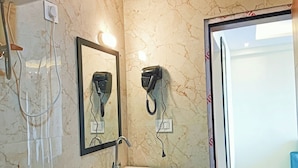 Une salle de bain avec un mur en marbre, un lavabo, un sèche-cheveux et un miroir.