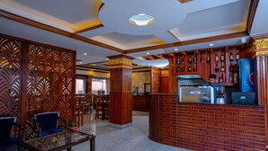 A lobby with a reception desk, seating area, and a bar. - Satkar Hotel and Spa (Kathmandu)