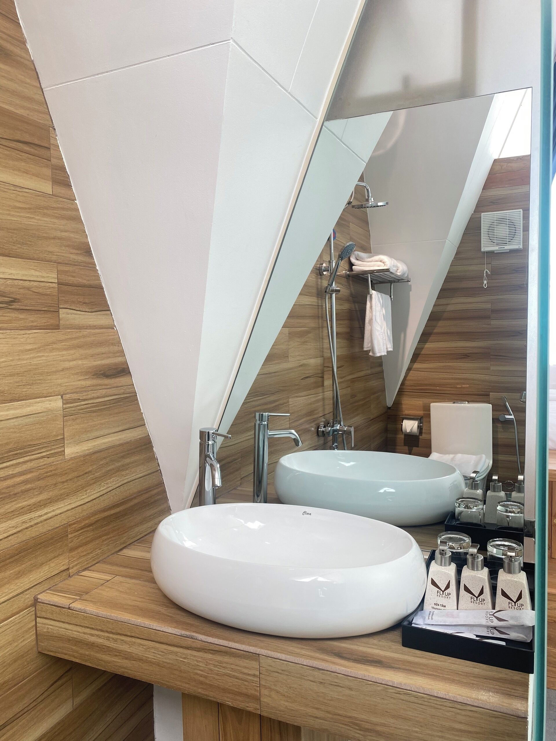 A modern bathroom with two sinks, a large mirror, and a shower.