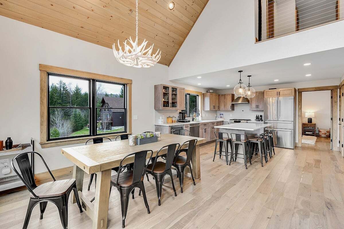 Una cocina amplia con armarios de madera, una isla grande y un comedor con sillas.