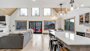 Una cocina amplia con una isla grande, varias ventanas y un techo alto.
