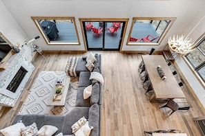 Een modern interieur met een bank, eettafel en rode stoelen.