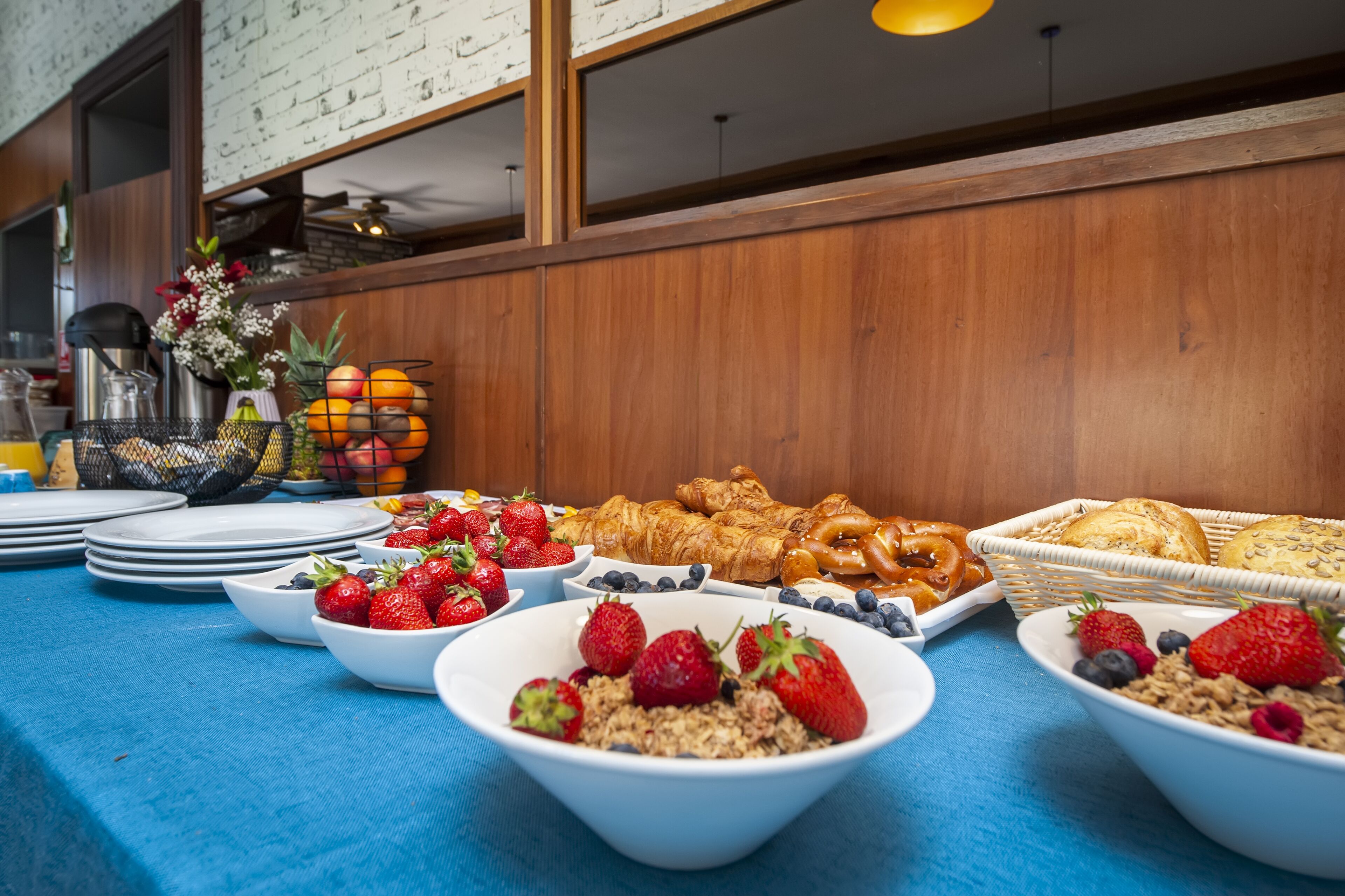 Un bufé de desayuno con diversas opciones de comida y tazones de fruta.