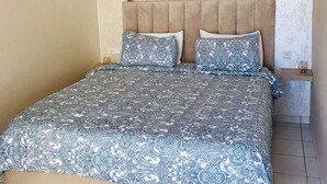 A bedroom with a large bed, two wall-mounted sunburst mirrors, and a chandelier. - Duplex Calme Cosy 5 Minutes du Centre d Essaouira (Essaouira)