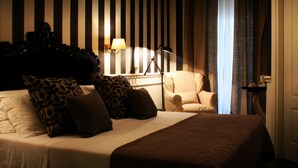 A hotel room with a bed, a chair, a lamp, and a window with curtains. - The B Place Ezio (Rome)