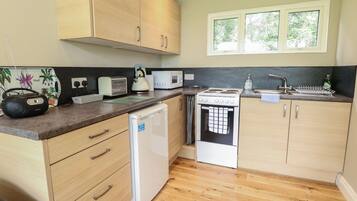 Cottage | Private kitchen | Fridge, electric kettle, toaster, cookware/dishes/utensils