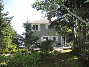Stroll up to the charming entrance, surrounded by lush greenery and a beautifully landscaped garden.