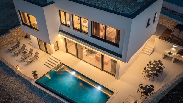 A modern two-story house with a swimming pool, outdoor seating, and a well-lit patio area. - Villa Ponti ZadarVillas (Novigrad)