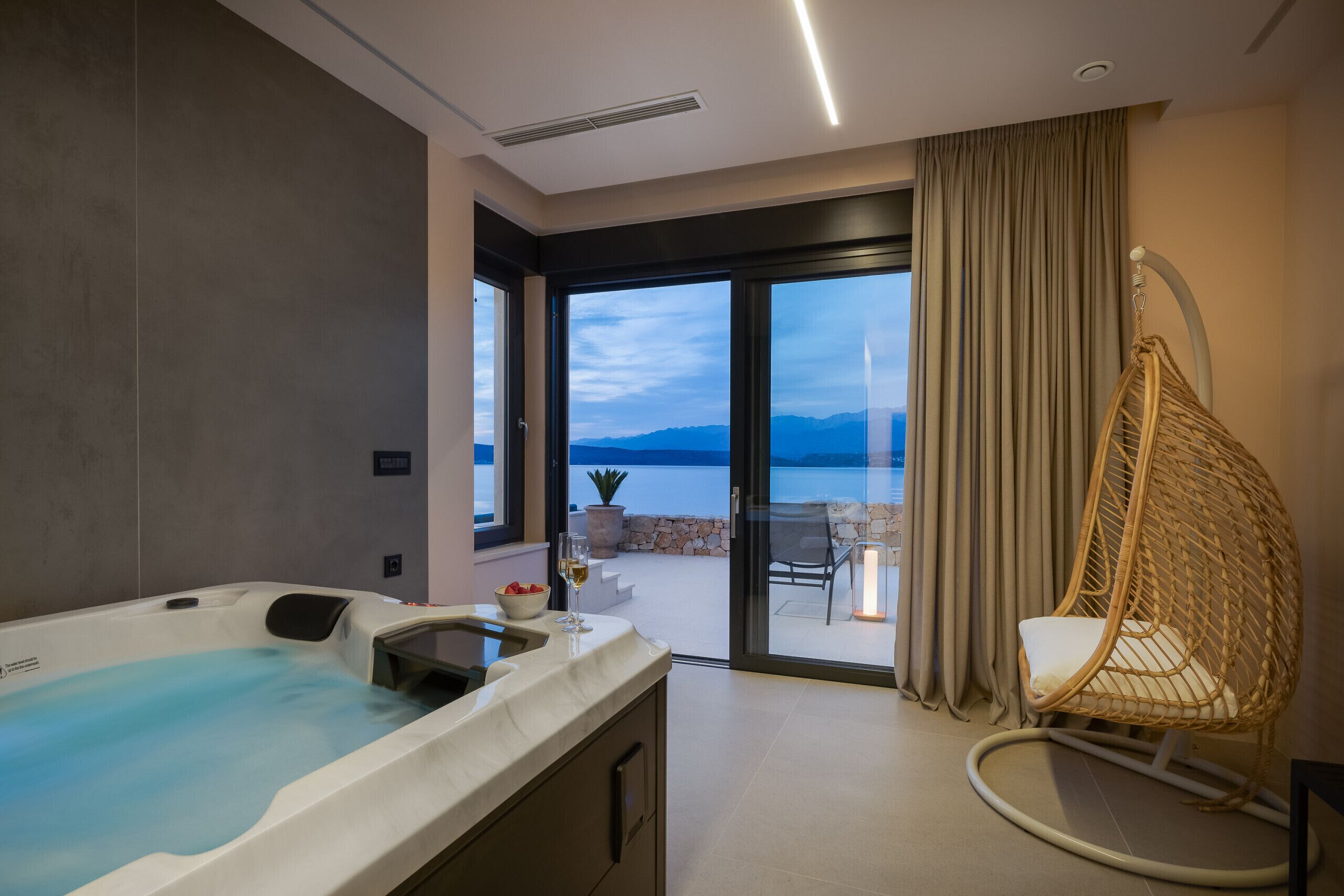 A modern bathroom with a bathtub, a glass shower, and a view of the outdoors.