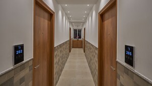 Un couloir d’hôtel avec des portes numérotées 202 et 205.