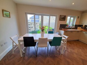 A modern kitchen with a dining area, large windows, and a view of the backyard. - Nr sea modern house parking garden 2.5 bathrooms (Pool)