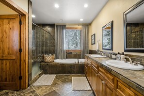 Une salle de bain avec deux lavabos, une baignoire et une douche.
