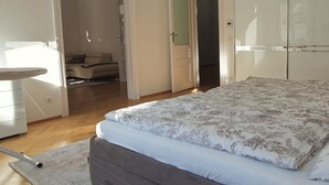 A bedroom with a bed, a wardrobe, a desk, and a chair. - Servicierte Wohnung in der City (Vienna)