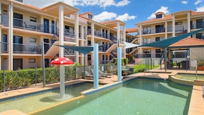 A multi-story hotel with a swimming pool, outdoor seating, and a distinctive red mushroom decoration. - 202 South Pacific, Pacific Drive (Port Macquarie)