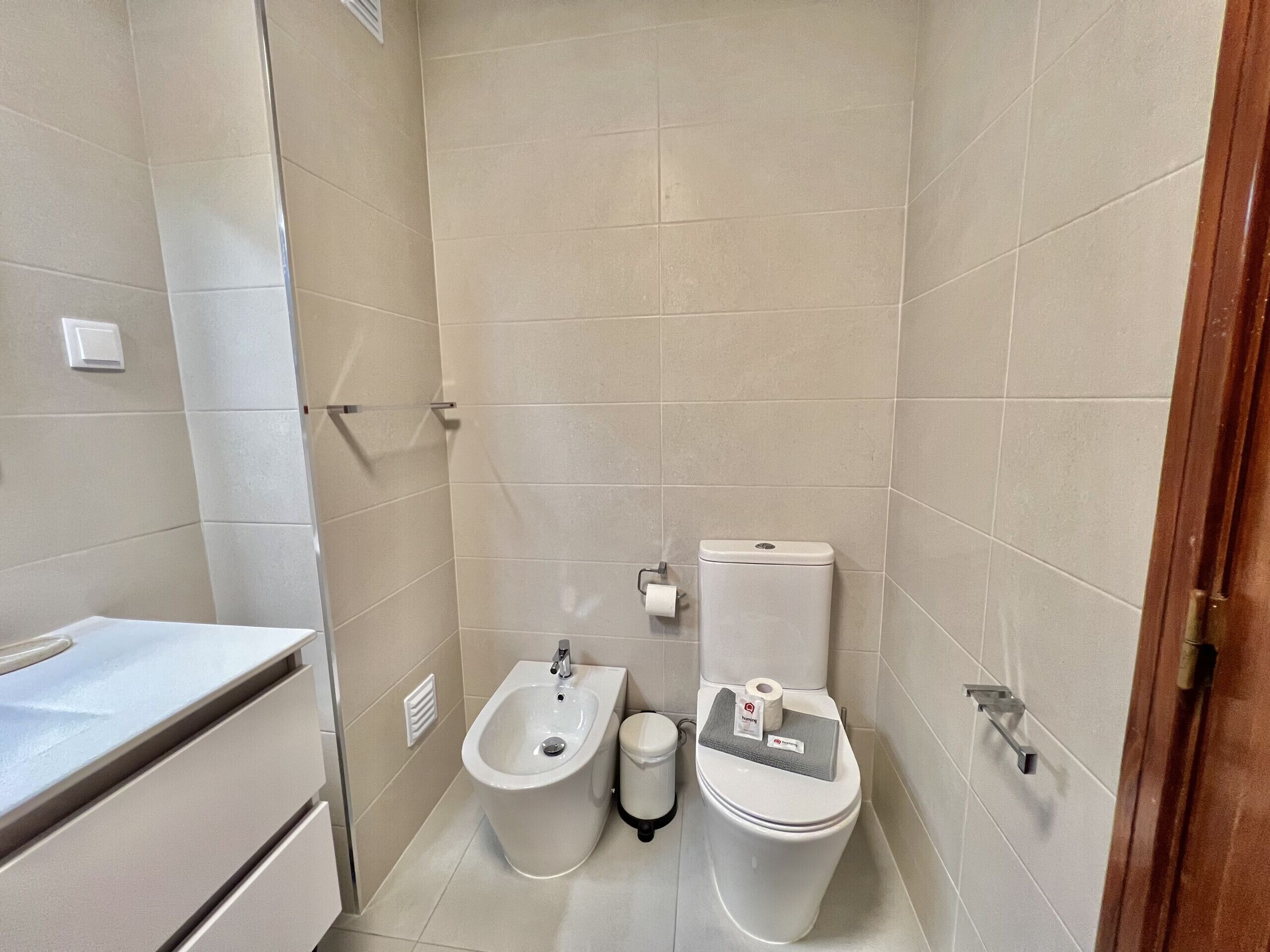 Une petite salle de bain moderne équipée d’un bidet, de toilettes et d’un lavabo.