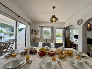 A dining area with a table set for breakfast, including plates, cups, and various food items. - Vilamoura Ocean Villa With Pool (Loulé)