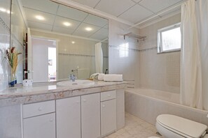 A bathroom with a sink, mirror, and bathtub. - Albufeira Concept With Pool by Homing (Albufeira)