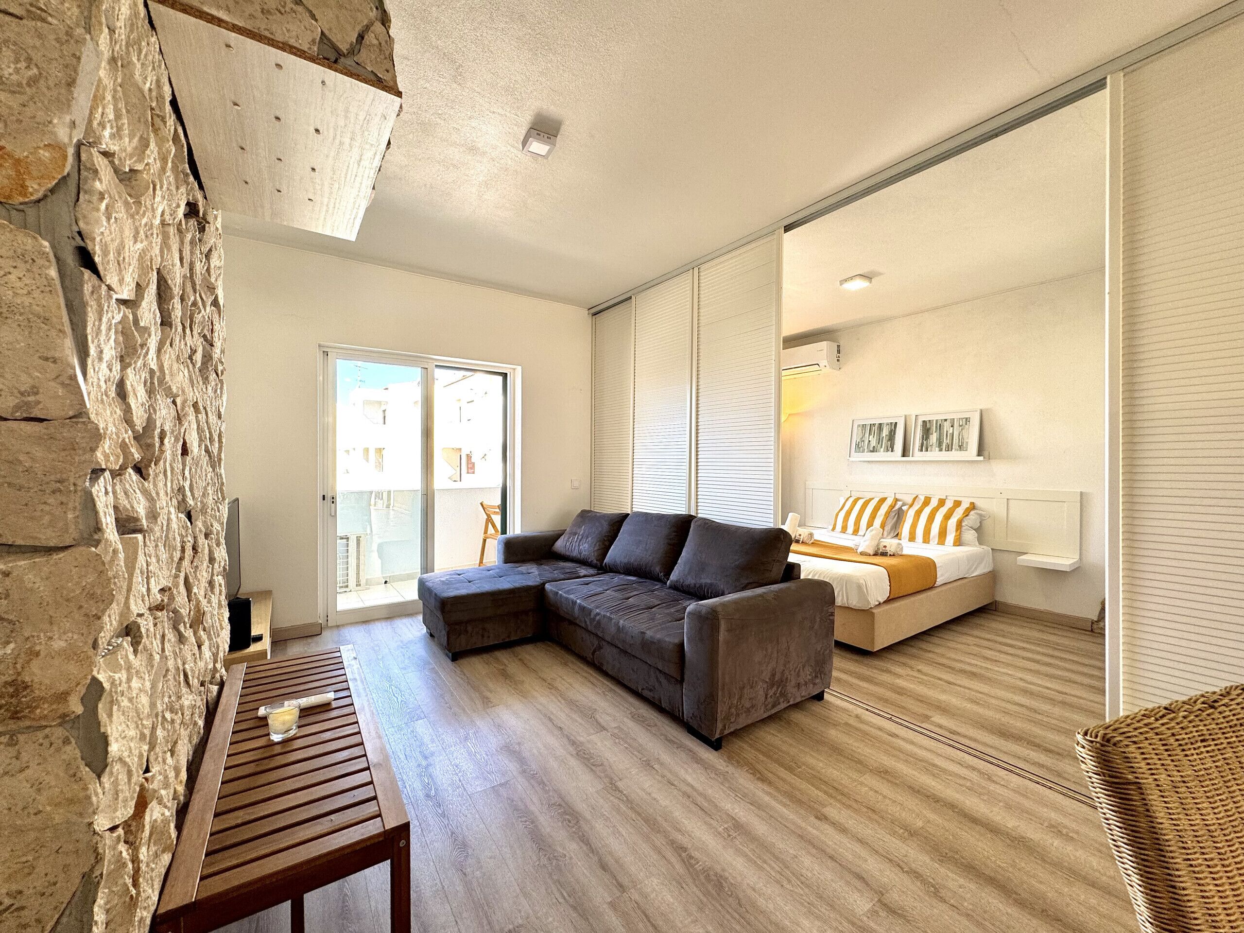 A modern living room with a sectional sofa, a wooden table, and a large window.
