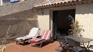 A rooftop patio with a table and chairs, a lounge chair, and a small potted plant. - Appartement Climatisé Avec Terrasse à Vidauban (Vidauban)