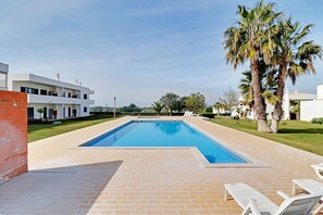 A rectangular swimming pool with a tiled edge, surrounded by a brick patio. - Pera Sea View With Pool by Homing (Silves)