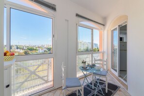 Ein Balkon mit Tisch, Stühlen und einer Obstschale.