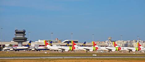 A row of Ryanair and Portugal Air planes parked at an airport.